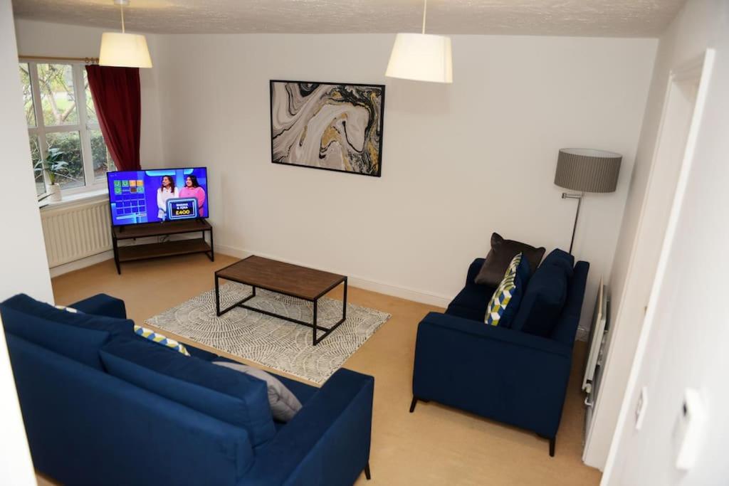 - un salon avec deux canapés bleus et une télévision dans l'établissement Charming 3 Bed House in Bristol, à Bristol