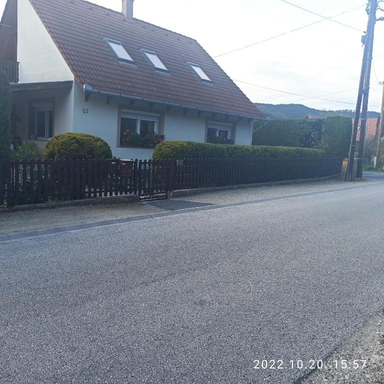 dom z płotem na poboczu drogi w obiekcie Marika apartman w mieście Balatongyörök