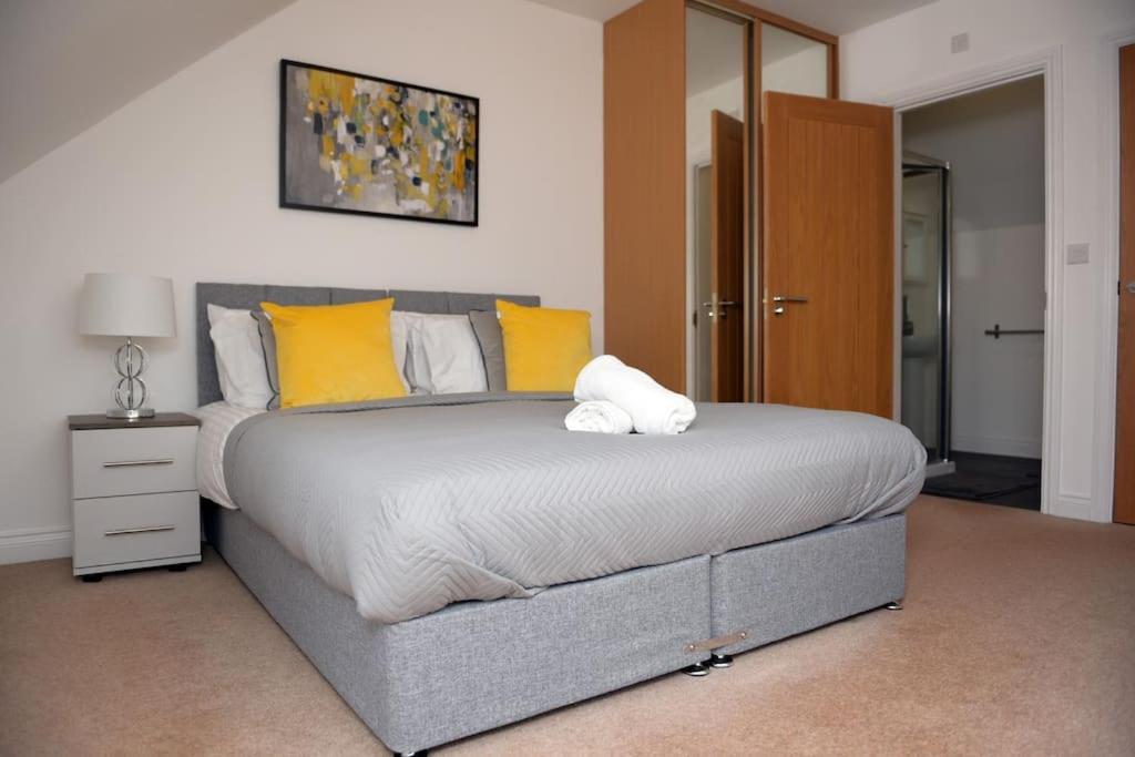 a bedroom with a large bed with yellow and white pillows at Spacious 3 Bed House in Bristol in Bristol