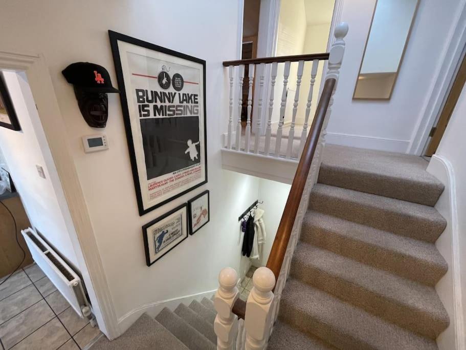 a hallway with a stairway with a stair railing and a stair case at Spacious two bedroom flat in prestigious Highgate. in London