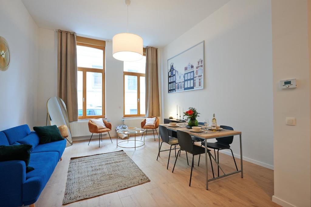 ein Wohnzimmer mit einem blauen Sofa und einem Tisch in der Unterkunft South Cosy Residence in Brüssel
