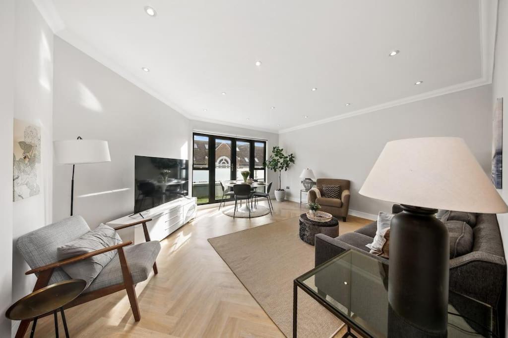 ein Wohnzimmer mit einem Sofa und einem Tisch in der Unterkunft 3bed Penthouse 10min to Wimbledon tennis courts in London