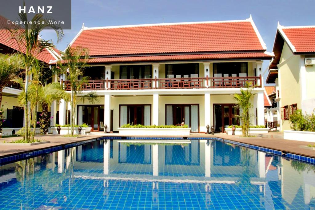 a villa with a swimming pool in front of a house at Sunrise Hotel Luang Prabang MekongRiver in Luang Prabang
