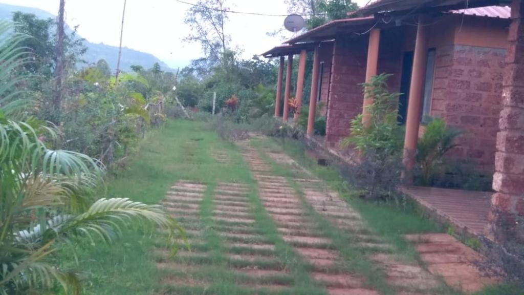 a path outside of a house next to a building at Vinee's Kitchen and Motel in Koynanagar