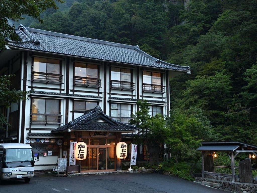 een gebouw met ramen en een auto die ervoor geparkeerd staat bij Kaniyu in Nikko