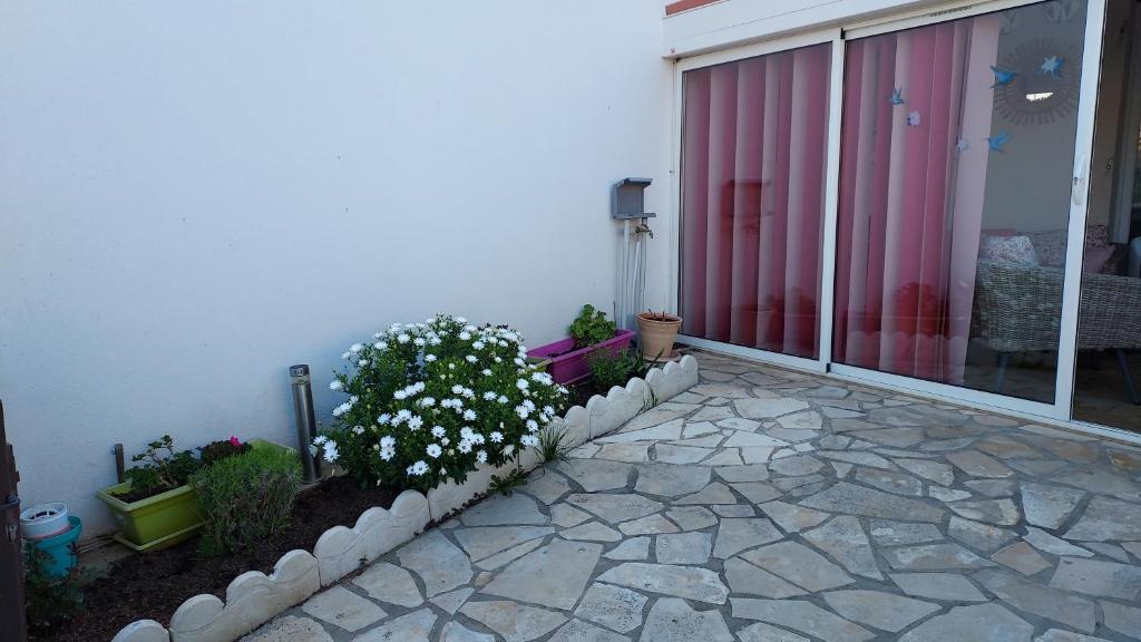 d'un patio avec des fleurs et des plantes sur le côté d'une maison. dans l'établissement belle Chambre avec sa salle de bain privée, à Marseillan