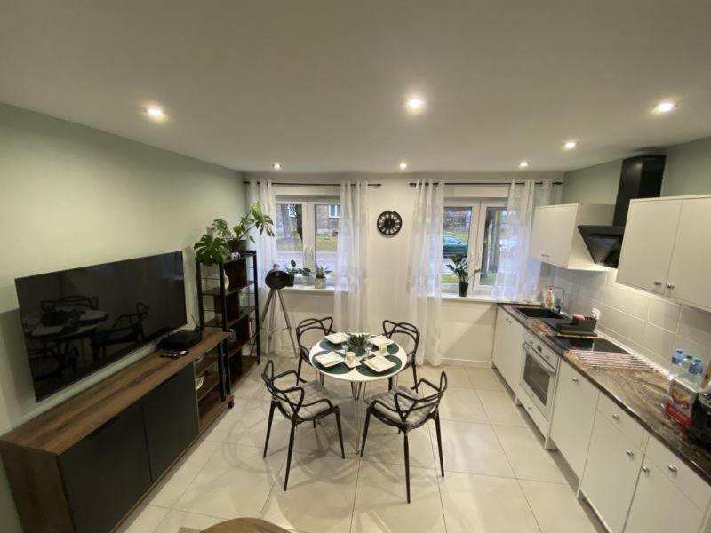 a kitchen with a table and chairs in a room at Apartament Błogi Sen III - komfortowy nocleg w spokojnej lokalizacji in Zabrze