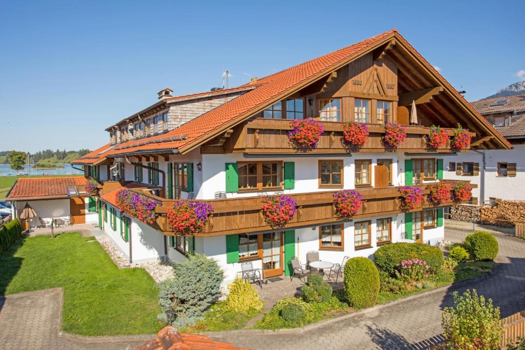 Una casa grande con flores al costado. en Ferienhaus Haußmann, en Schwangau