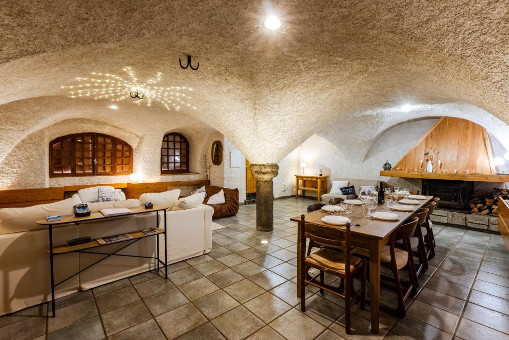 a living room with a couch and tables and a fireplace at Les Cabris - Duplex pied de pistes au Bez in La Salle Les Alpes