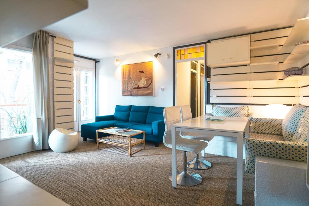 a living room with a blue couch and a table at Gavà Beach Apartment in Gavà