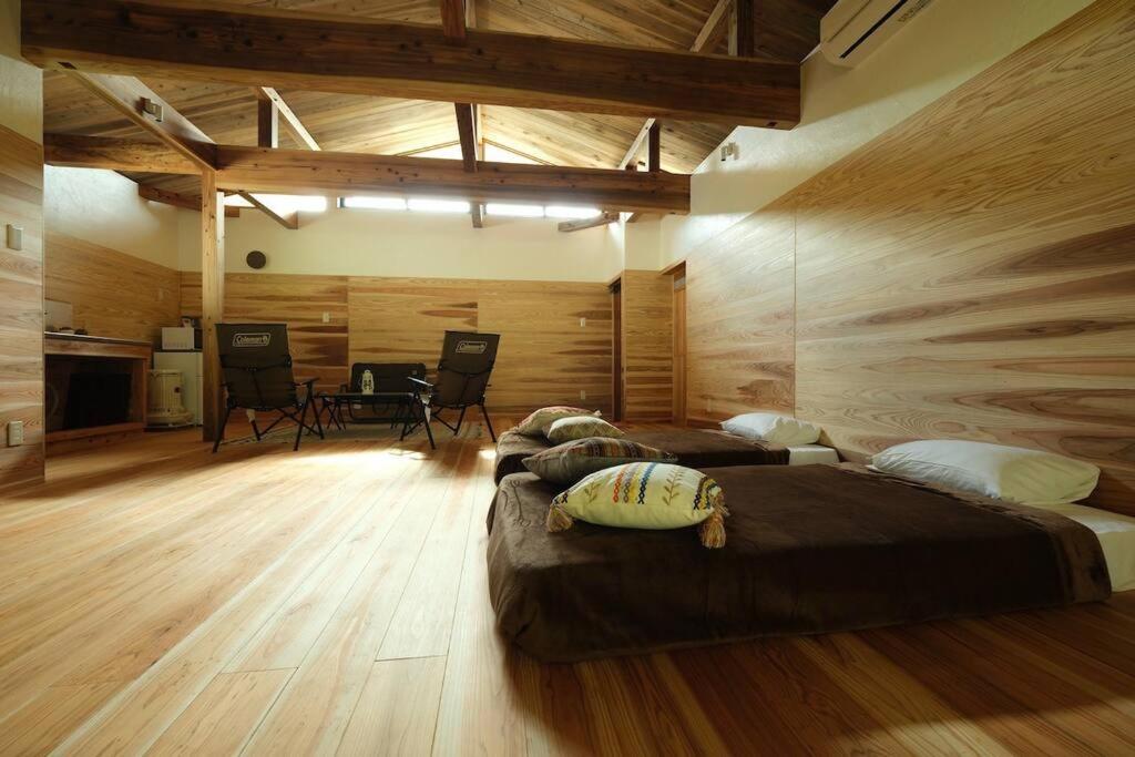 Cette chambre comprend 3 lits et une table. dans l'établissement スナッパーロック 屋久島, à Yakushima