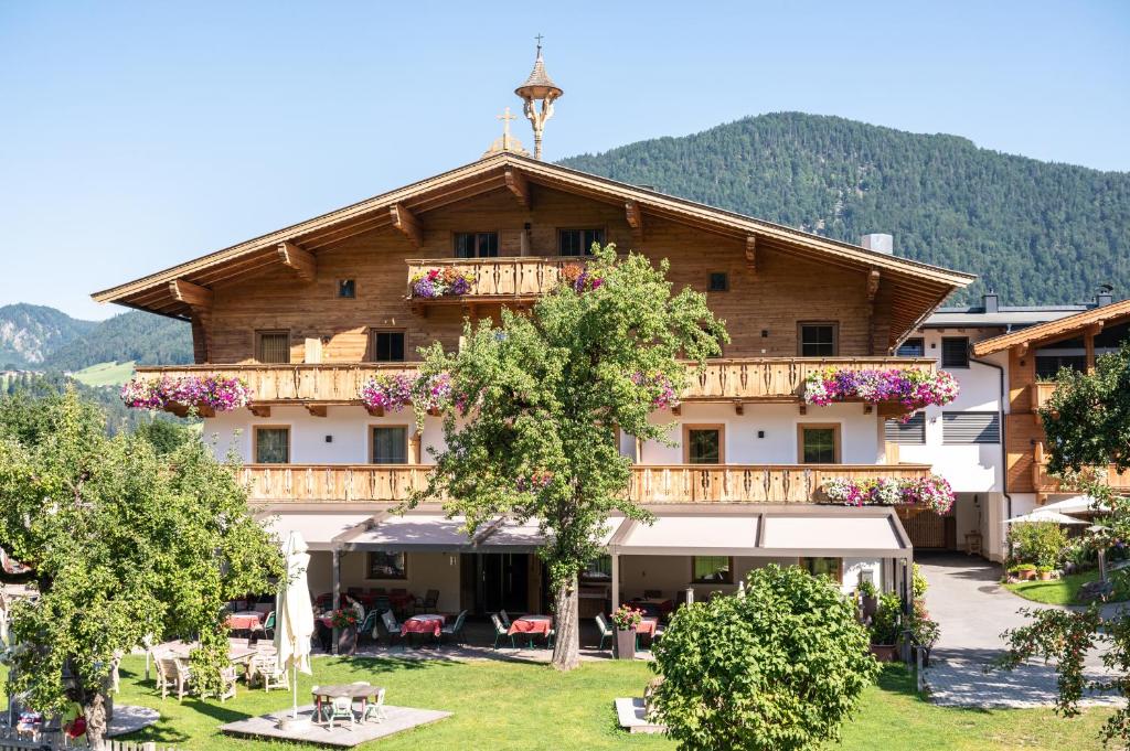 ein großes Gebäude mit Bäumen davor in der Unterkunft Erlebnisgut & Reiterhof Oberhabach in Kirchdorf in Tirol