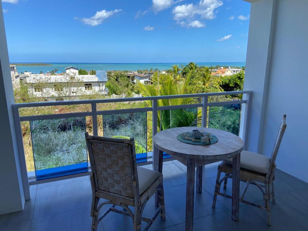 a table and chairs on a balcony with a view of the ocean at Morne Side Apartments in La Gaulette