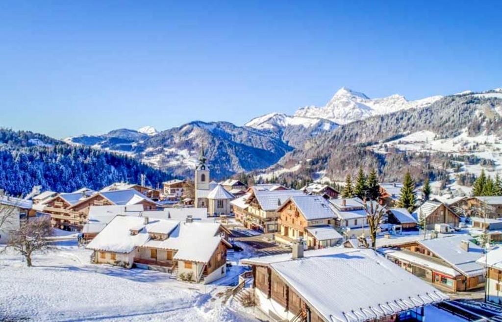 a village covered in snow with mountains in the background at Appartement d'une chambre a Notre Dame de Bellecombe a 400 m des pistes avec terrasse in Notre-Dame-de-Bellecombe