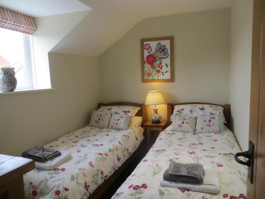 1 dormitorio con 2 camas y ventana en Easter Cottage, en Dersingham