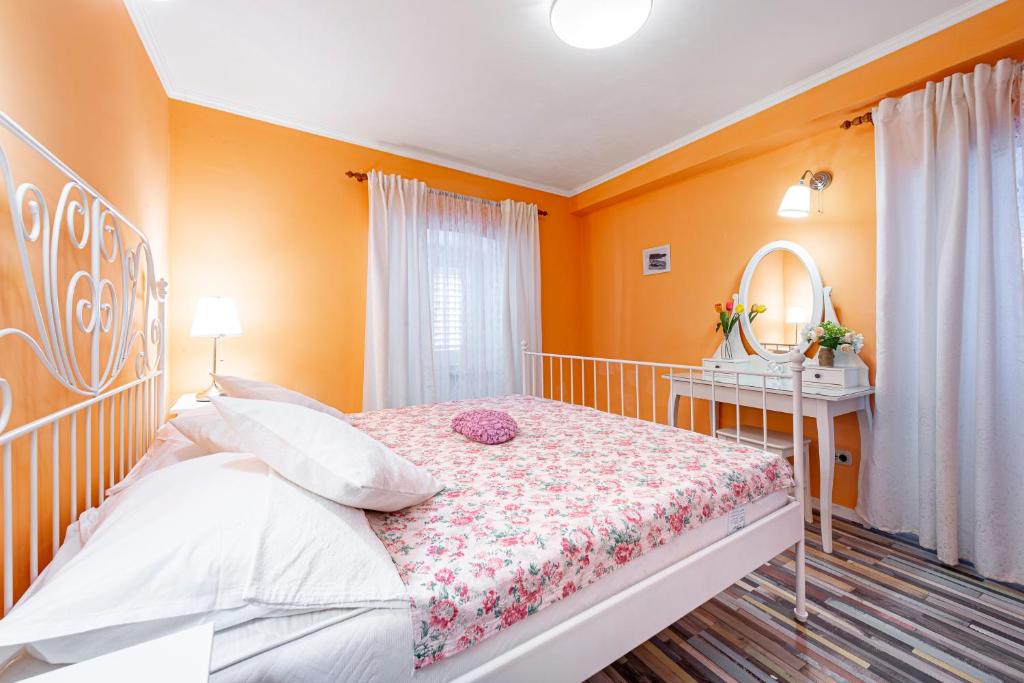 a bedroom with orange walls and a bed and a mirror at Apartments Vera in Dubrovnik