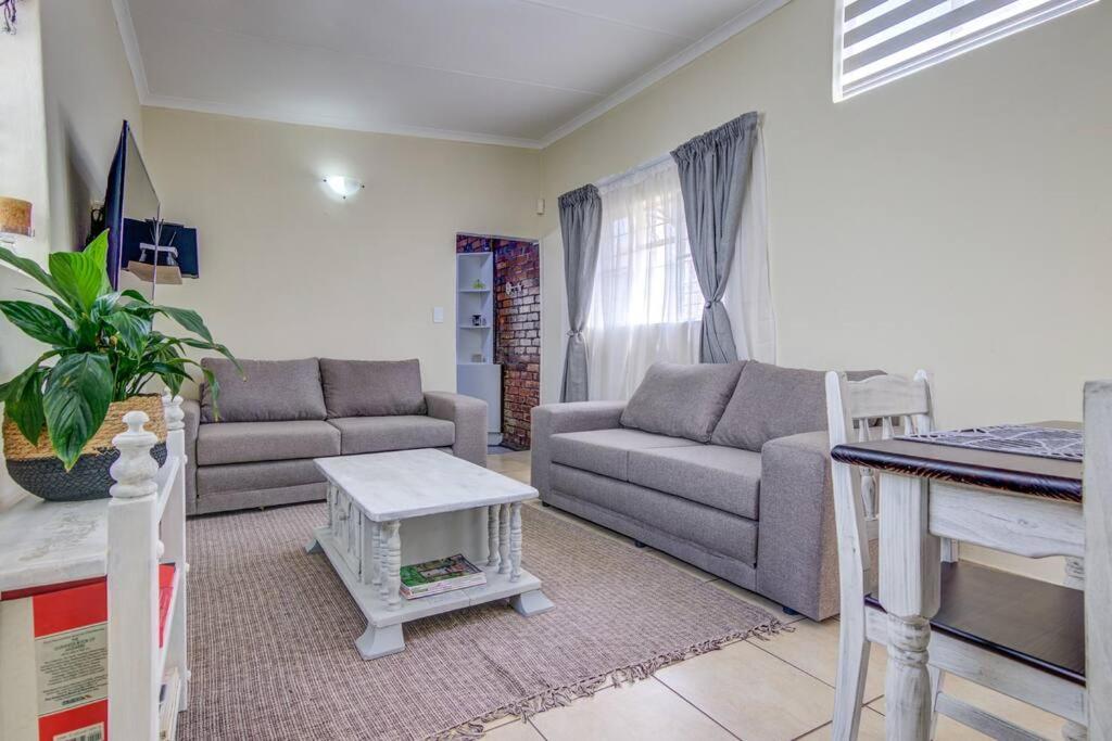 a living room with a couch and a table at Ovendales Self Catering Cottage in Benoni