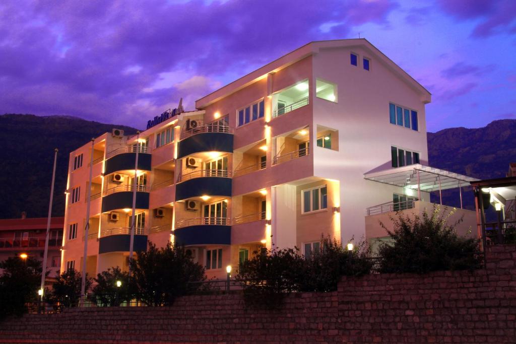 un gran edificio blanco con luces delante en Hotel Bella Vista, en Budva