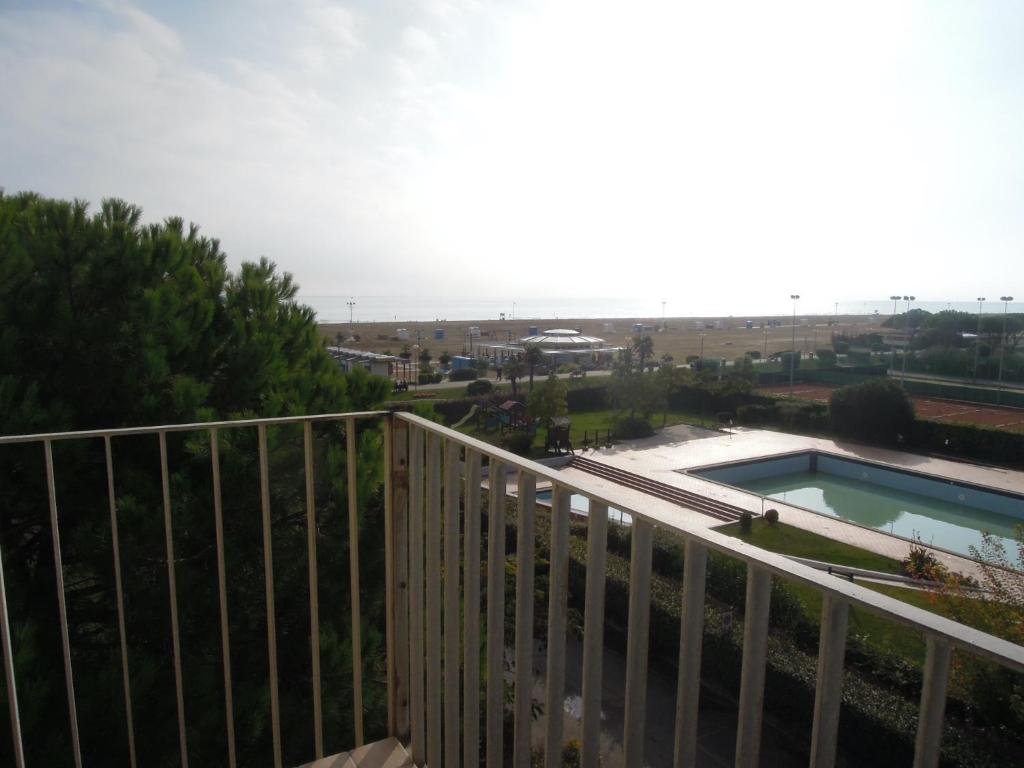 a balcony with a fence and a swimming pool at Homely 1 bedroom flat with side sea view in Bibione