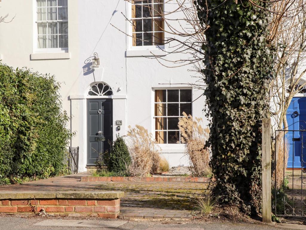una casa blanca con una puerta negra en Crud Yr Awel, en Canterbury