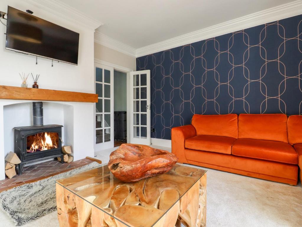 a living room with a couch and a fireplace at Crud Yr Awel in Canterbury