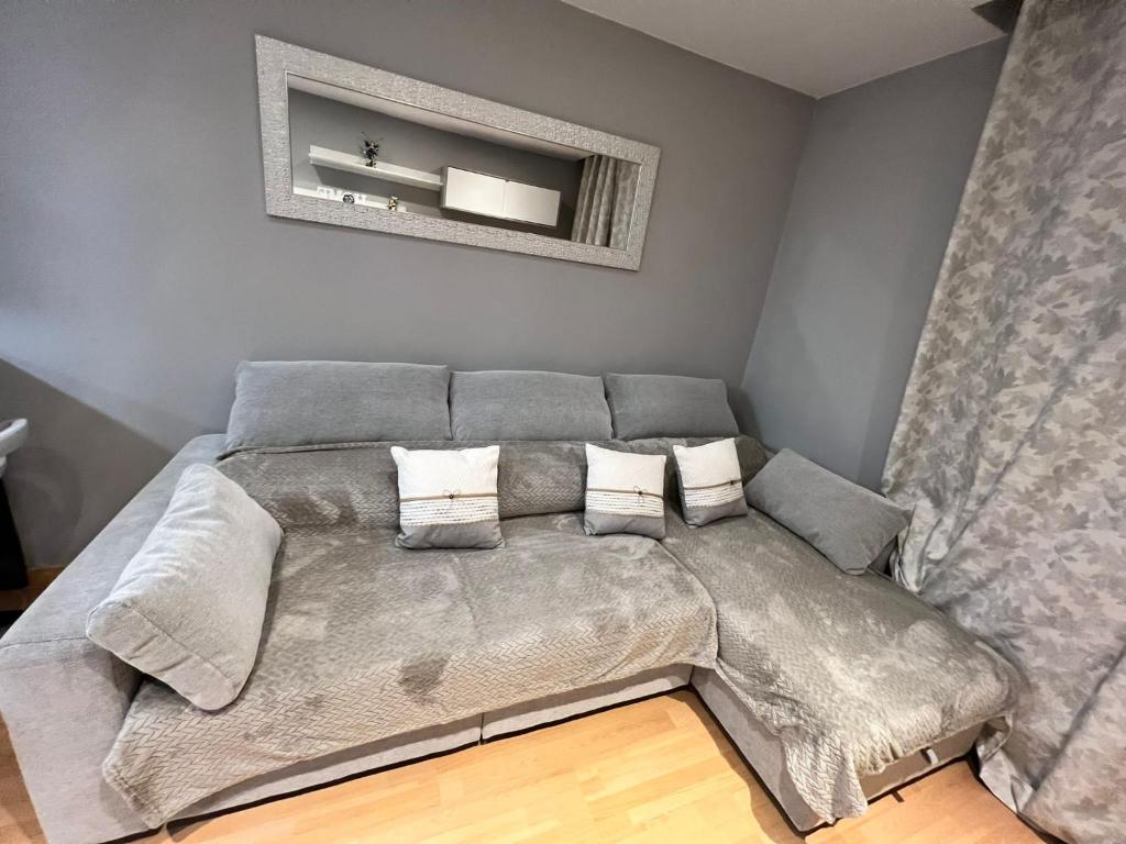 a living room with a couch with pillows at Apartamento Zaragoza Centro in Zaragoza