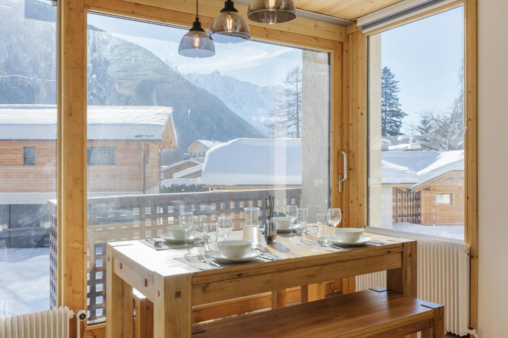 a dining room with a table and a large window at Residence de Lognan- Les Jorasses 27 - Happy Rentals in Chamonix