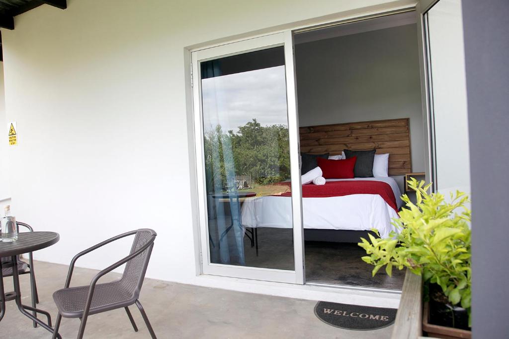 - une chambre avec un lit et une porte coulissante en verre dans l'établissement Zero90, à Swellendam