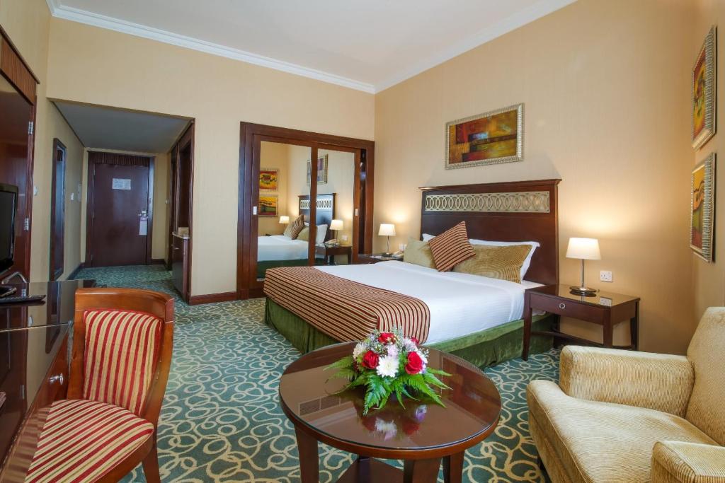 a hotel room with a bed and a living room at Concorde Hotel Fujairah in Fujairah