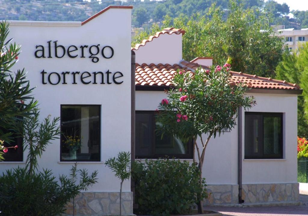 un cartello per un albergo torrerite di fronte a un edificio di Albergo Torrente a Vieste