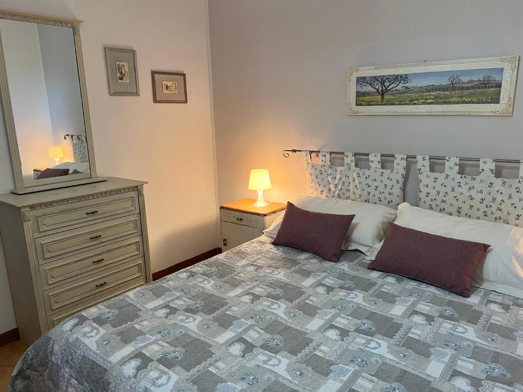 ein Schlafzimmer mit einem Bett und eine Kommode mit einem Spiegel in der Unterkunft Casa vacanze La Via del Mare in Scanzano