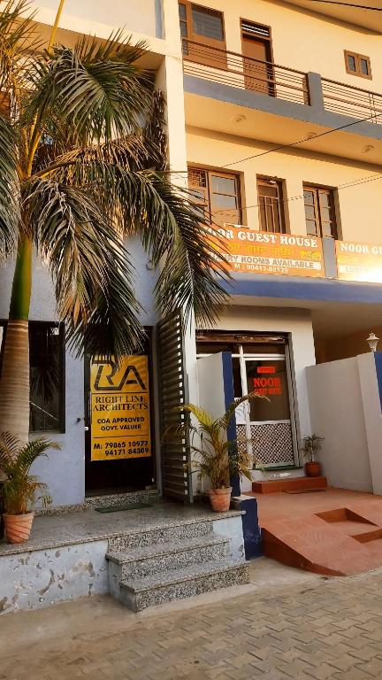 un edificio con palmeras delante en NOOR Inn & Guest House -Couples Favorite,Local ID Accepted -- High Rated by Couples en Jalandhar