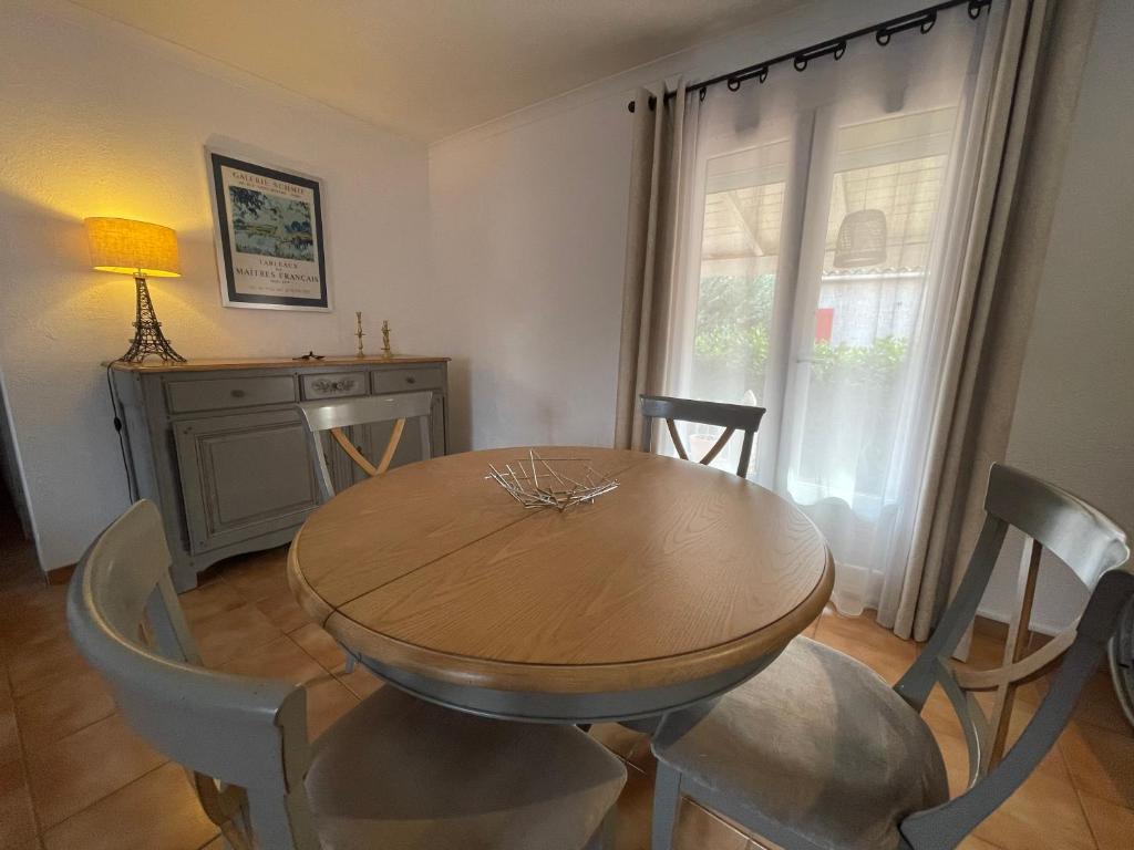 - une salle à manger avec une table et des chaises en bois dans l'établissement Confortable villa de vacances entre Nîmes, le Pont du Gard, Uzès, Arles, Avignon, à Marguerittes