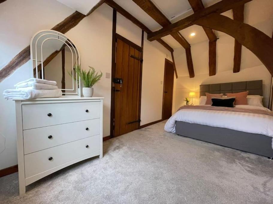 1 dormitorio con 1 cama blanca y vestidor blanco en Rural Country Suites - Judge's Lodge, en East Grinstead