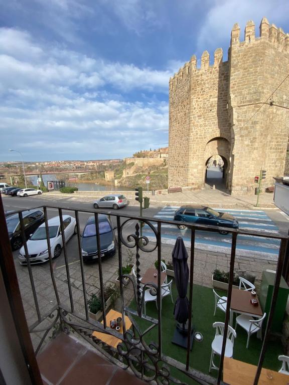 a balcony with cars parked in front of a castle at The Bridge house of Toledo in Toledo