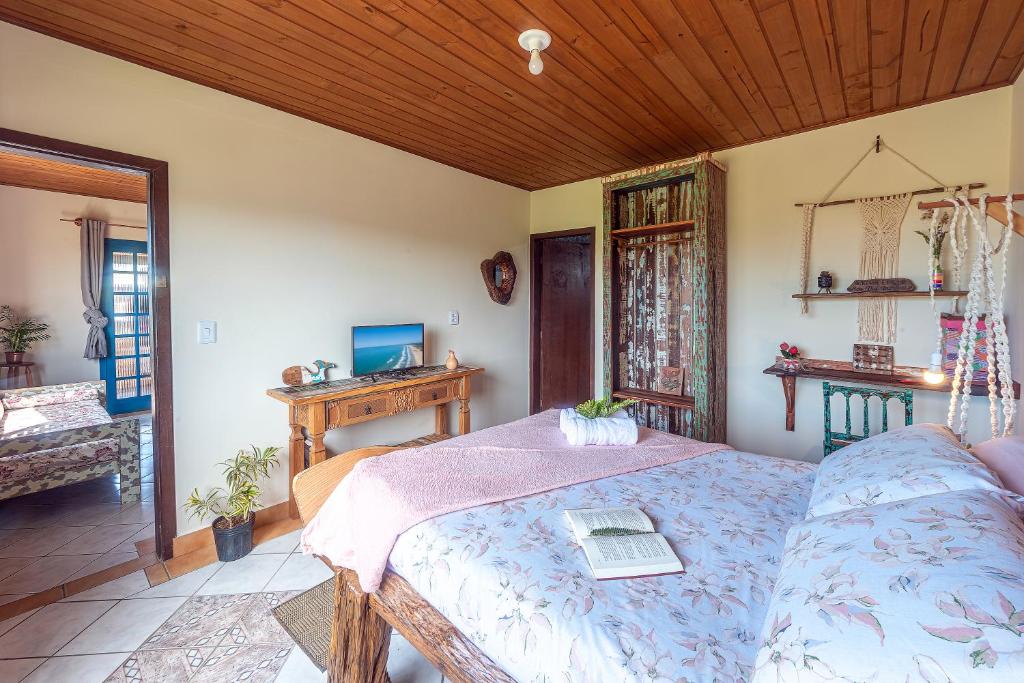 uma sala de estar com uma cama e um sofá em Praia Itápiruba 600m - WI-FI 800Mg - 1,5km BR 101 - Espaço comp - Varanda c Pôr do sol em Imbituba