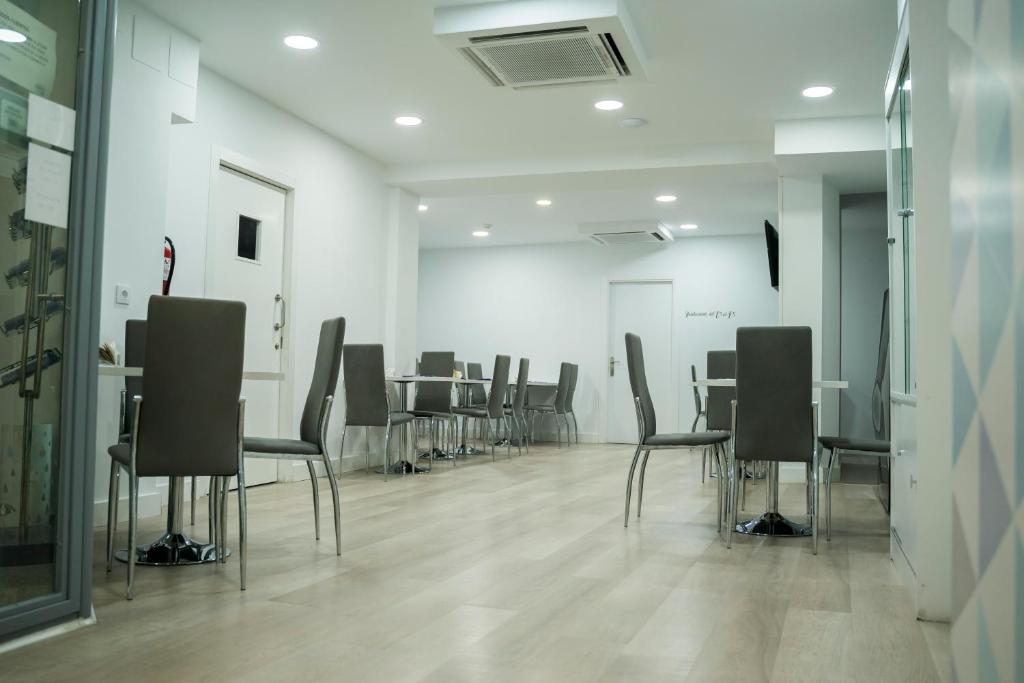una sala de conferencias con una mesa larga y sillas en Hostal Goyesco Plaza, en Plasencia