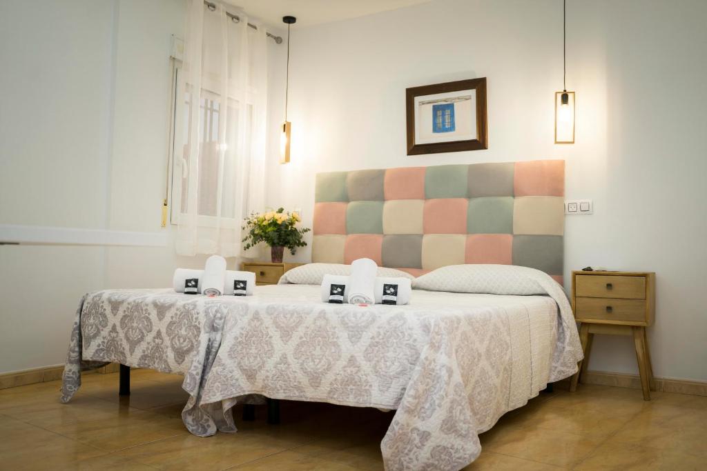 1 dormitorio con 1 cama con 2 velas en una mesa en Hostal Goyesco Plaza, en Plasencia