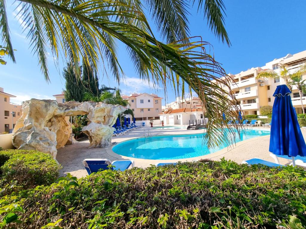een zwembad met een palmboom en een hotel bij Yaar Apartment with pool, tennis court and Bathroom with Bathtub in Pyla