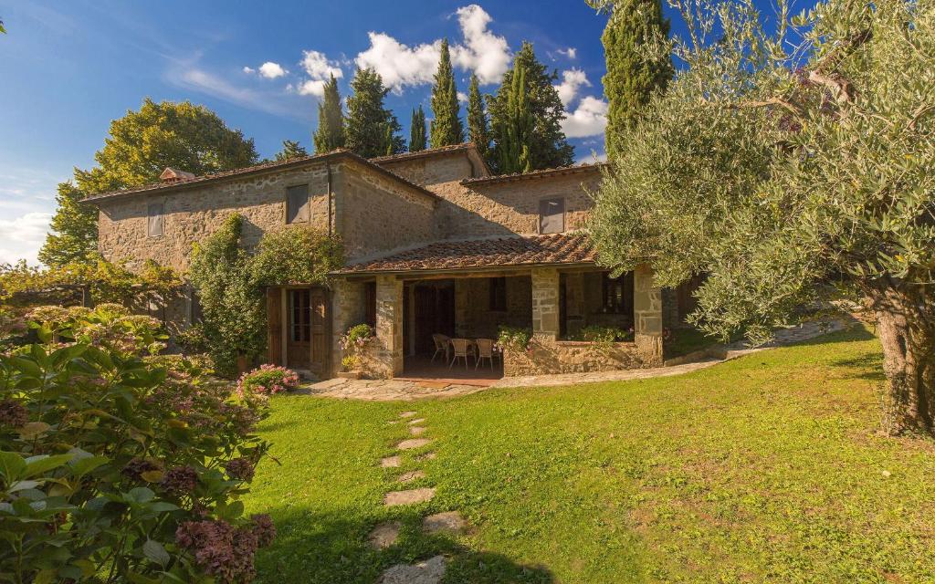 a large stone house with a grass yard at Pozza di Volpaia by Salogi Villas in Radda in Chianti