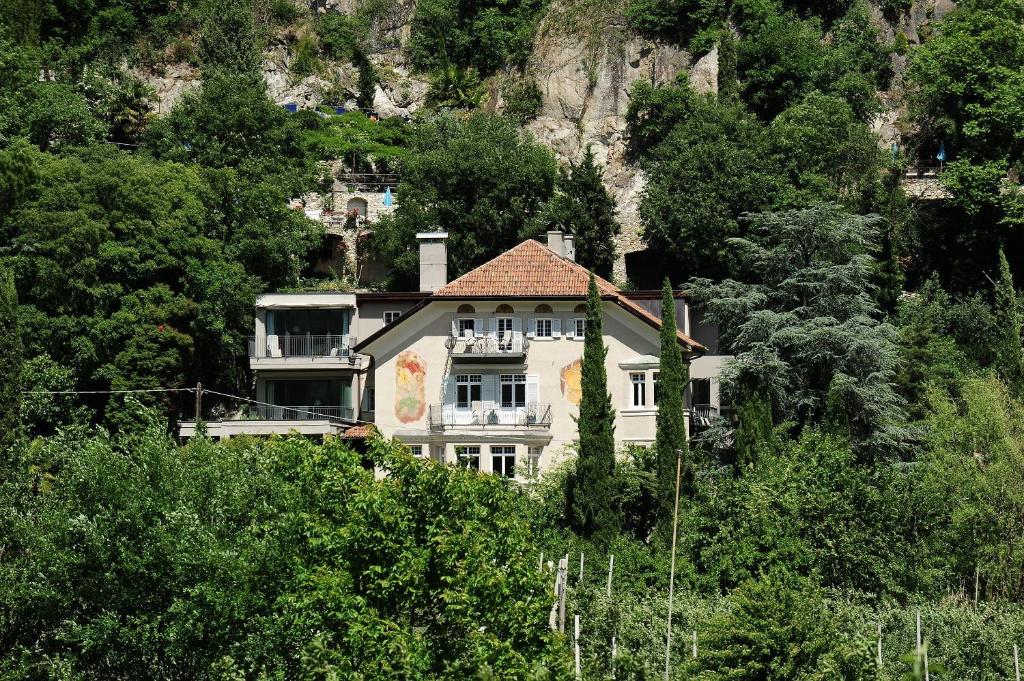une maison sur le flanc d'une montagne dans l'établissement Villa Verdi Apartments, à Merano