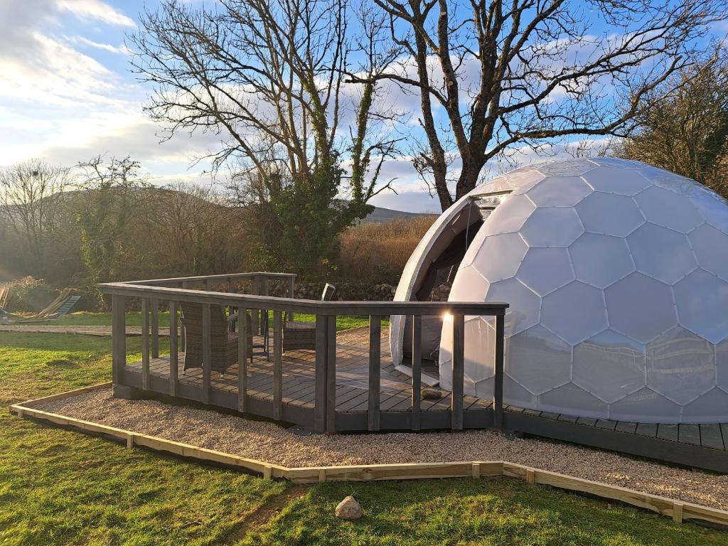 een grote koepeliglo met een terras in het gras bij Luxury Glamping Dome with views of the Burren in Boston