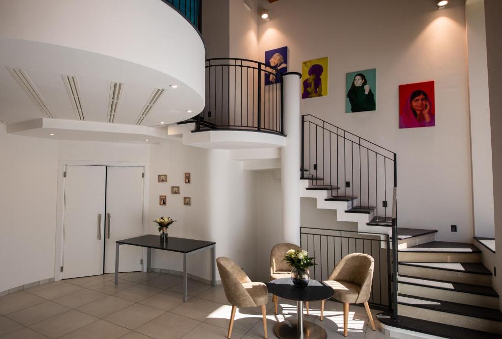sala de estar con escaleras, mesa y sillas en Lei Rooms, en Maranello