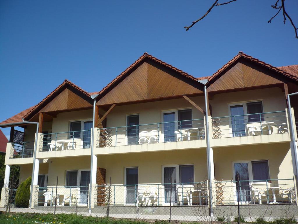 a large building with chairs on the balcony at Jankó Apartmanház in Zalakaros