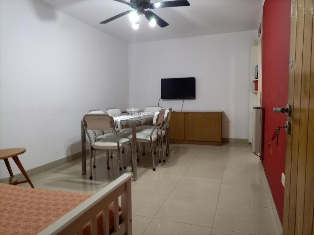 uma sala de jantar com mesa e cadeiras e uma televisão de ecrã plano em Edificio Los andes - n11 em Villa Carlos Paz