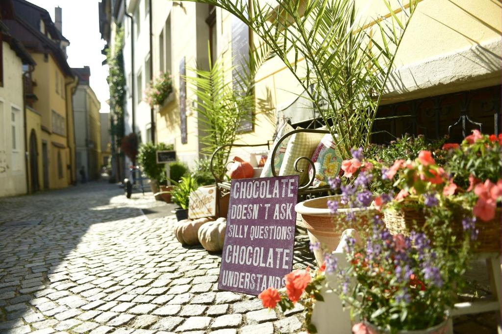 ein Schild auf einer Straße mit Blumen und Pflanzen in der Unterkunft Alte Konditorei in Lindau