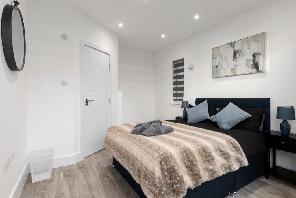 a bedroom with a black bed and a white wall at Star London Vivian Avenue 3-Bed Oasis with Garden in The Hyde
