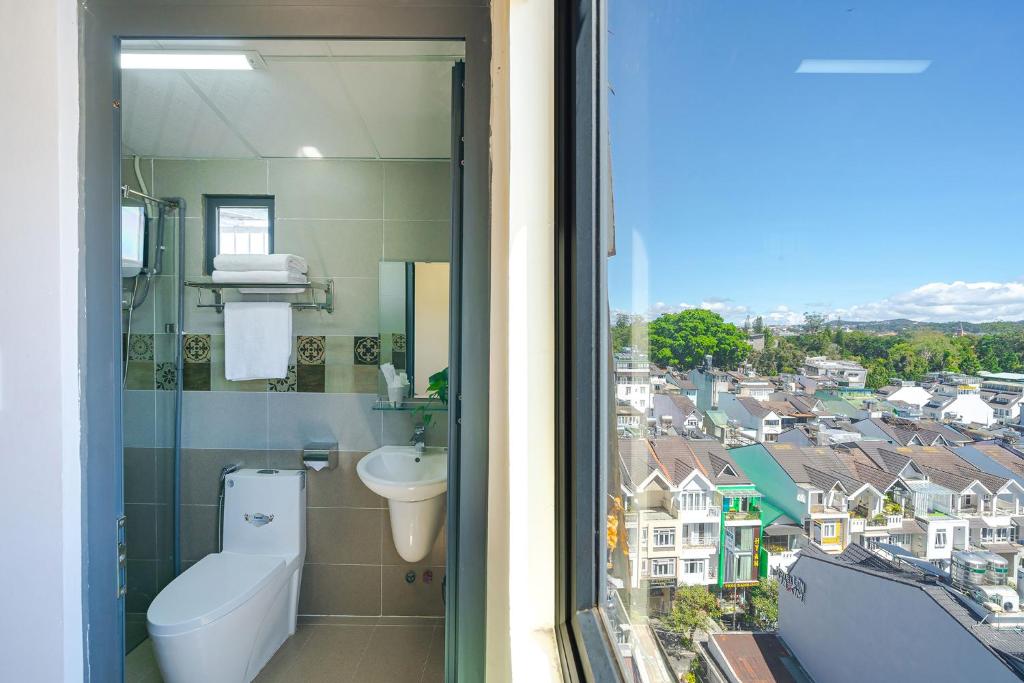 een badkamer met een toilet, een wastafel en een raam bij AN Boutique Hotel - STAY 24H in Da Lat