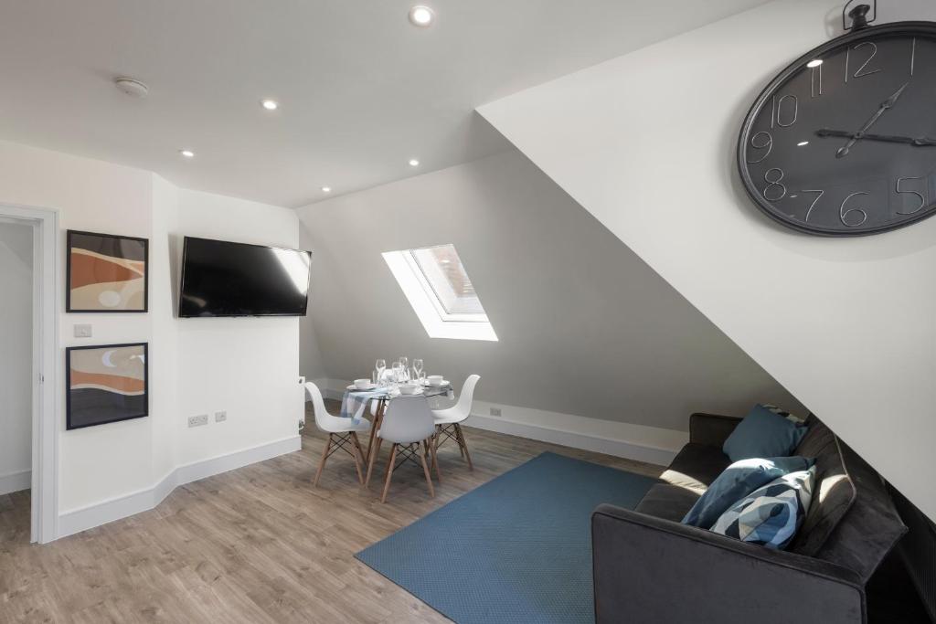 een woonkamer met een klok en een tafel bij Flat 5 - Star London Vivian Lane 2-Bed Residence in The Hyde