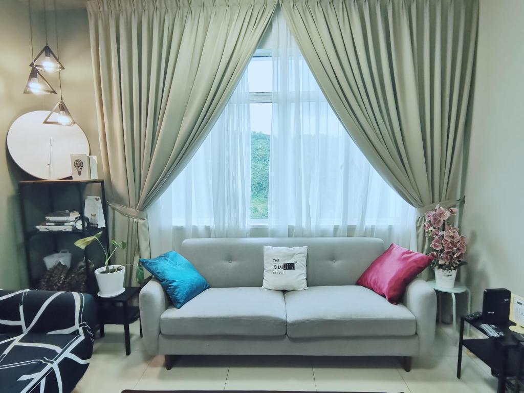 a living room with a couch and a large window at The Khailily's Guest in Sepang